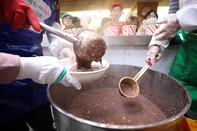 절기상 동지(冬至)인 22일 서울 종로구 조계사에서 열린 팥죽 나눔행사에서 자원봉사자들이 팥죽을 나눠주고 있다.2018.12.22 뉴스1