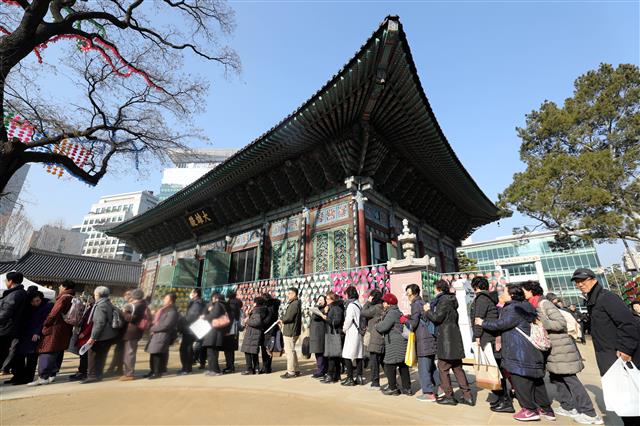 절기상 동지(冬至)인 22일 서울 종로구 조계사에서 열린 팥죽 나눔행사를 찾은 많은 시민들이 길게 줄지어 서 있다.2018.12.22 뉴스1