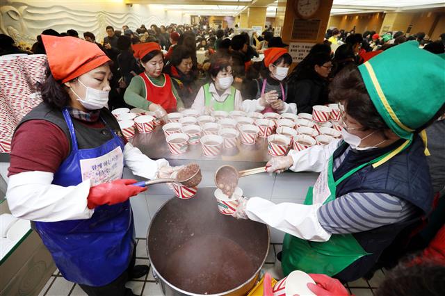 절기상 동지(冬至)인 22일 서울 종로구 조계사에서 열린 팥죽 나눔행사에서 자원봉사자들이 팥죽을 나눠주고 있다.2018.12.22 뉴스1