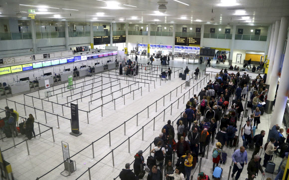 지난 22일(현지시간) 드론 침입으로 한동안 폐쇄됐다가 문을 다시 연 영국 런런의 개트윅 공항에서 비행기를 타려는 승객들이 줄을 서서 기다리고 있다. 개트윅 AP 연합뉴스