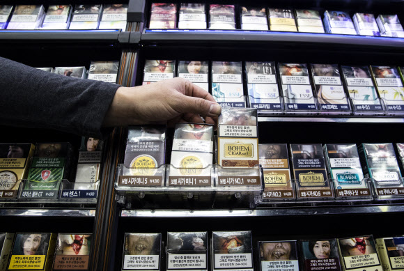 23일 오전 서울 종로구의 한 편의점에서 관계자가 흡연의 위험성을 알리는 경고그림이 변경된 담뱃갑을 들어보이고 있다. 2018.12.23 연합뉴스