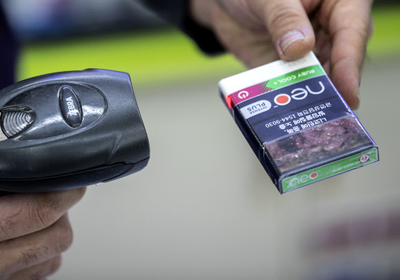 23일 오전 서울 종로구의 한 편의점에서 관계자가 흡연의 위험성을 알리는 경고그림이 변경된 담뱃갑을 들어보이고 있다. 2018.12.23 연합뉴스