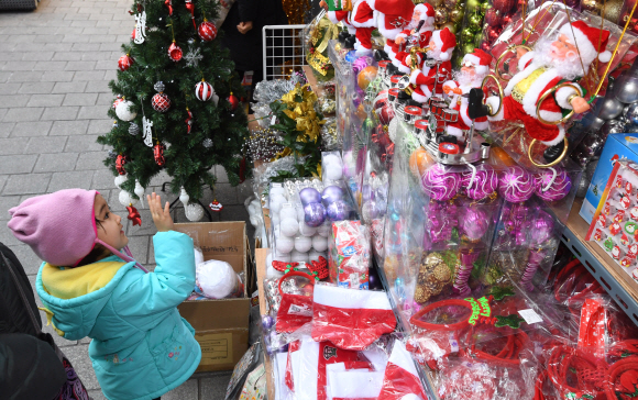 크리스마스를 이틀 앞둔 23일 오전 서울 남대문시장을 찾은 어린이가 산타인형에게 인사하고 있다. 2018.12.23. 도준석 기자 pado@seoul.co.kr