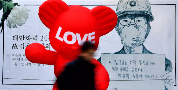 24일 서울 광화문 세종문화회관에 걸린 고 김용균씨 추모 현수막 앞으로 시민들이 지나고 있다. 2018.12.24 박지환기자 popocar@seoul.co.kr