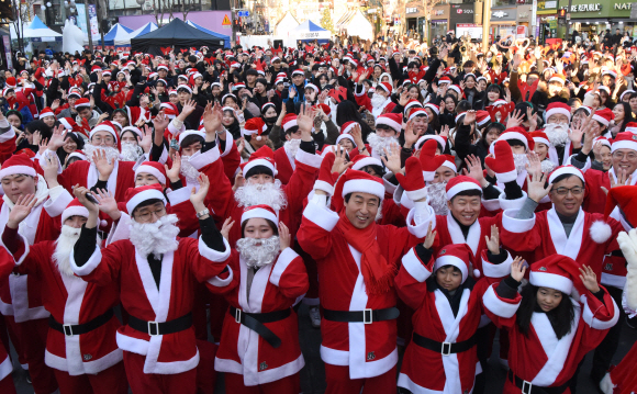 성탄절을 하루 앞둔 24일 서울 서대문구 신촌 연세로에서 열린 ‘사랑의 몰래산타’출정식에서 산타로 분장한 자원봉사자들이 포즈를 취하고 있다. 이들은 행사를 마치고 서울지역의 소외계층 아동 및 청소년을 찾아가 선물을 전달할 예정이다. 2018.12.24. 이종원 선임기자 jongwon@seoul.co.kr