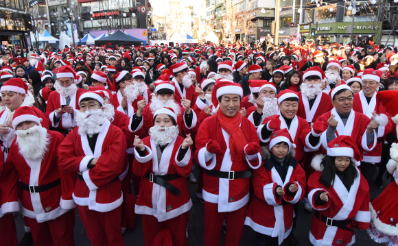성탄절을 하루 앞둔 24일 서울 서대문구 신촌 연세로에서 열린 ‘사랑의 몰래산타’출정식에서 산타로 분장한 자원봉사자들이 포즈를 취하고 있다. 이들은 행사를 마치고 서울지역의 소외계층 아동 및 청소년을 찾아가 선물을 전달할 예정이다.2018.12.24. 이종원 선임기자 jongwon@seoul.co.kr