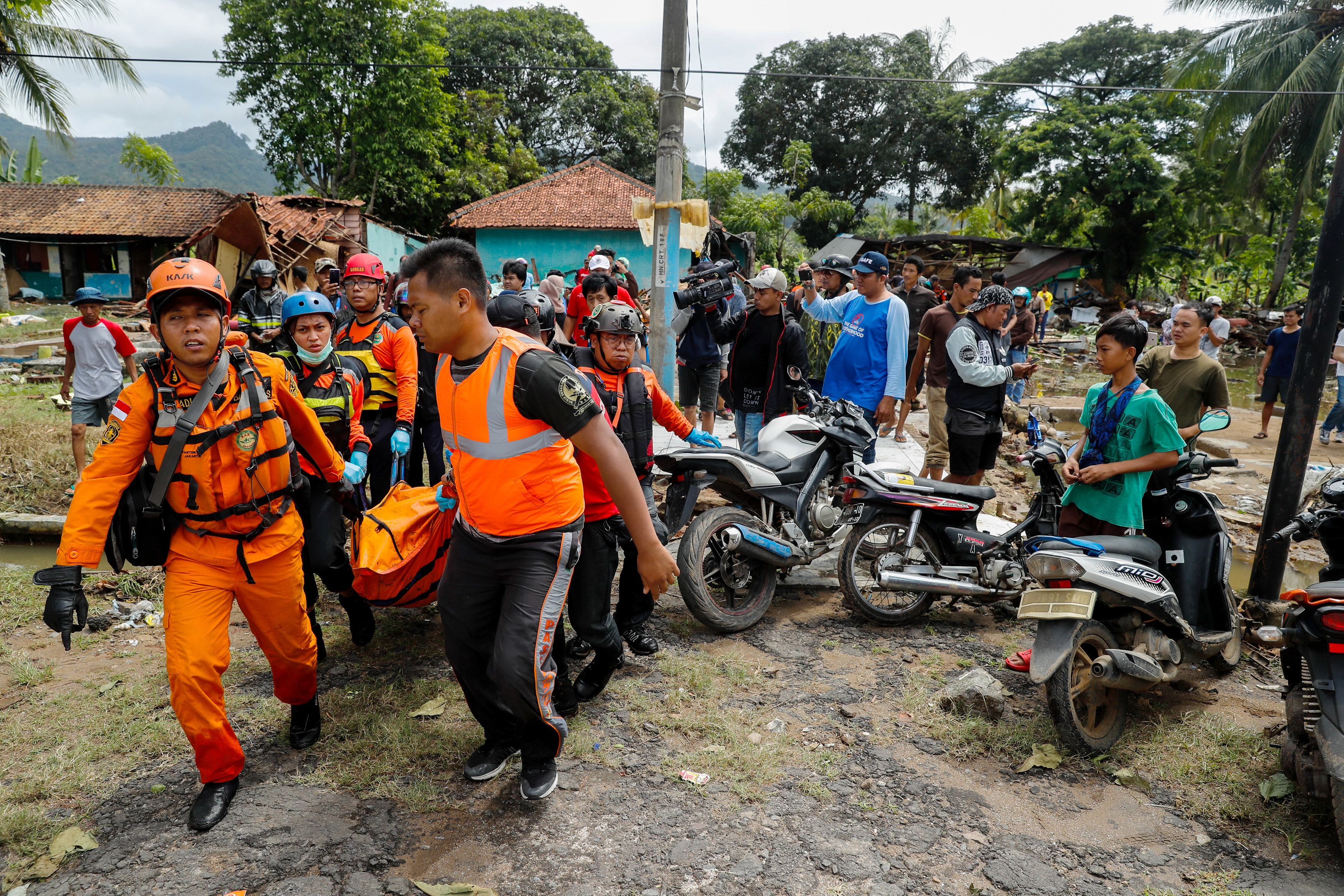 이틀 전 쓰나미가 휩쓸고 간 인도네시아 반텐 주 판데글랑의 한 호텔 앞 해변에서 24일(현지시간) 구조대원들이 수습한 시신을 옮기고 있다. AP 연합뉴스
