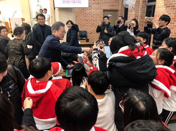 문재인 대통령이 24일 오후 경남 양산시 덕계 성당에서 열린 성탄 전야 미사에 참석해 어린이들과 인사하고 있다. 2018.12.25  청와대 제공