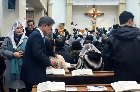 문재인 대통령과 부인 김정숙 여사가 24일 오후 경남 양산시 덕계 성당에서 열린 성탄 전야 미사에 참석해 영성체를 마친 뒤 자리로 돌아오고 있다. 2018.12.25  청와대 제공