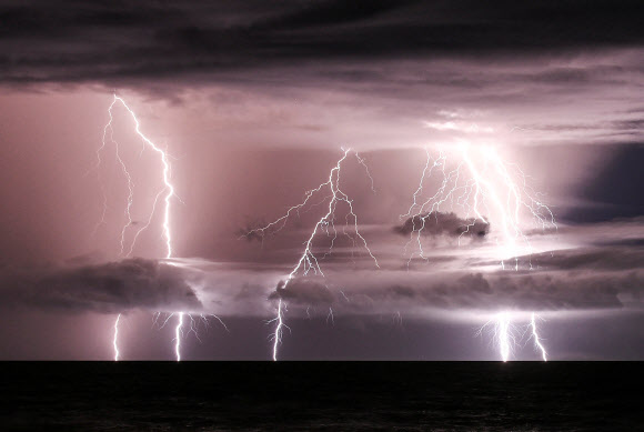 25일 인도네시아 자바섬과 수마트라섬 사이 해협에 번개같은 전류가 드러나고 있다. 이 사진은 노출시간을 길게 해 찍었다. 지난 22일 인도네시아 자바섬 인근 아낙 크라카타우 화산이 분화하면서 쓰나미가 발생해 이날까지 사망자가 429명에 이르고 있다. 2018.12.25. AFP 연합뉴스