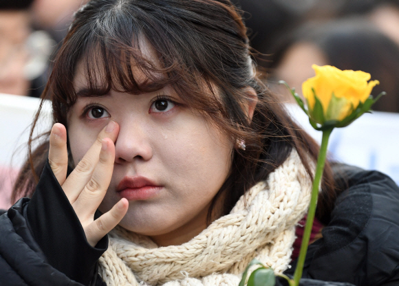 26일 서울 종로구 구 일본대사관 앞에서 진행된 ‘제1367차 수요정기집회’에서 한 참가자가 눈물을 훔치고 있다. 2018. 12. 26.  박윤슬 기자 seul@seoul.co.kr