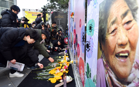 26일 서울 종로구 옛 일본대사관 앞에서 열린 ‘일본군 성노예제 문제 해결을 위한 제1367차 정기 수요시위’에 참가한 시민들이 김복득 할머니 등 올해 세상을 떠난 피해 할머니 8명의 영정 앞에 장미꽃을 내려놓으며 고인의 넋을 기리고 있다. 박윤슬 기자 seul@seoul.co.kr