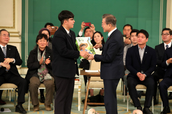 소년 농부의 땀이 어린 쌀 전달받는 문 대통령