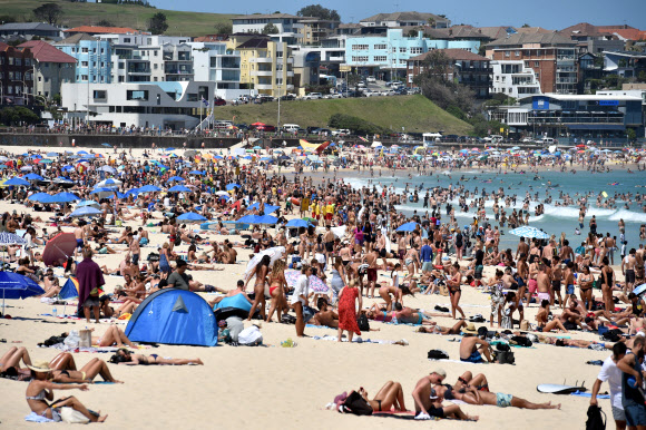 해수욕하는 사람들과 서퍼들이 29일(현지시간) 호주 뉴사우스웨일즈 시드니의 본다이 비치에서 즐거운 시간을 보내고 있다. 일기예보에 따르면 주말 내내 시드니에서는 섭씨 32도까지 오르는 무더위가 예상되고 있다. EPA 연합뉴스