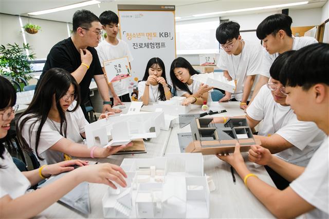 지난 8월 KB국민은행 충남 천안연수원에서 진행된 진로 체험 캠프에 참여한 고등학생들이 직접 설계한 모형 건물을 만들고 있다.  KB국민은행 제공