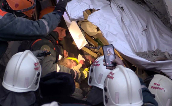 러시아 첼랴빈스크주 마그니토고르스크 아파트 붕괴 현장에서 구조대원들이 1일(현지시간) 생후 11개월 된 남자아이 바냐를 구조하고 있다.  마그니토고르스크 AFP 연합뉴스