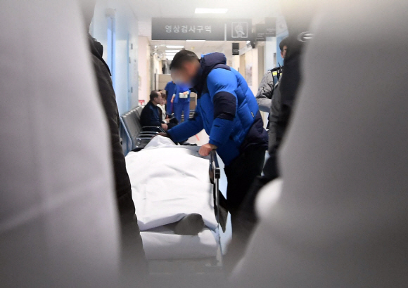 유서를 쓰고 자살을 시도한 신재민 전 기재부 사무관이 3일 서울 관악구 한 호텔에서 발견, 보라매병원 응급실로 후송돼 CT촬영을 위해 경찰 관계자들에게 둘러싸인 채 대기하고 있다. 신 전 사무관은 생명에는 지장이 없는 것으로 알려졌다. 2019. 1. 3  국민일보 제공