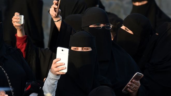 사우디아라비아 수도 리야드에서 북쪽으로 50㎞ 떨어진 알타마마 마을에서 열린 자나드리야 축제 도중 손전화를 꺼내 사진을 촬영하는 여성들. AFP 자료사진 