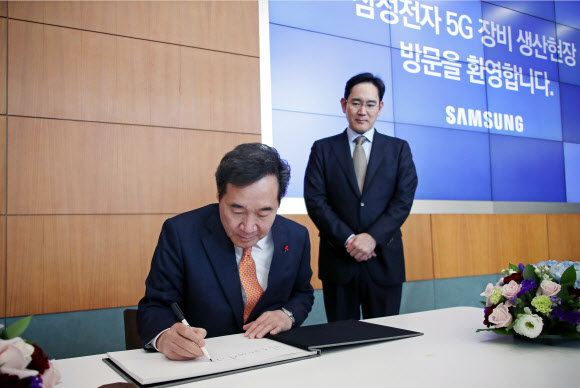 이낙연 국무총리(왼쪽)가 10일 경기도 수원시 삼성전자 5G 장비 생산 현장을 방문해 방명록을 작성하고 있다. 오른쪽은 이재용 삼성전자 부회장. 2019.1.10  연합뉴스