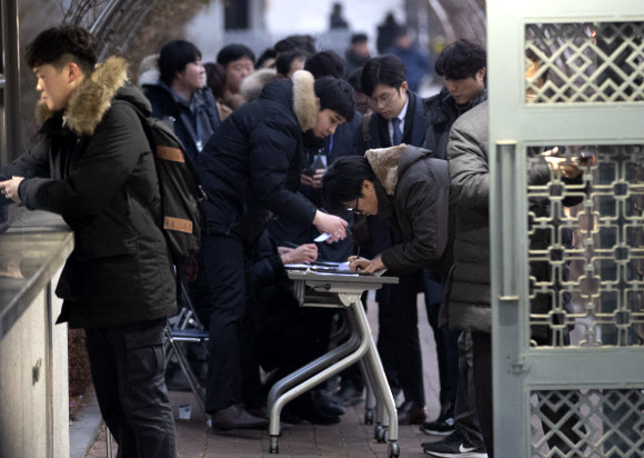 일제 강제징용 피해자 소송에 개입하고 ‘법관 블랙리스트’를 만드는 등 사법행정권을 남용했다는 의혹을 받고 있는 양승태 전 대법원장이 검찰 포토라인에 서는 11일 오전 서초구 서울중앙지검 입구에서 취재진이 출입비표를 받고 있다. 2019.1.11 연합뉴스