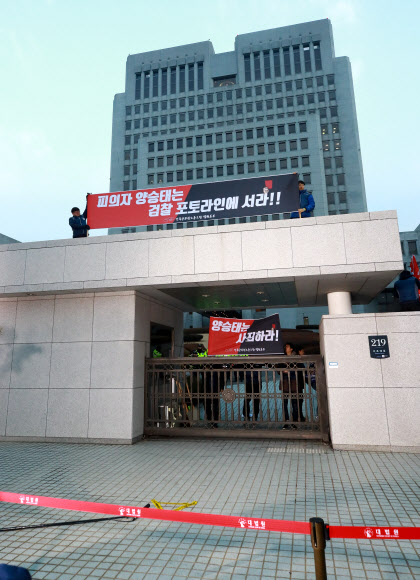 전국공무원노조 법원본부 조합원들이 11일 오전 서울 서초동 대법원 앞에서 사법행정권 남용 의혹 관련 검찰 소환을 앞두고 기자회견을 예정한 양승태 전 대법원장을 규탄하며 대법원 정문 위에 올라 펼침막을 들어보이고 있다. 2019.1.11  연합뉴스