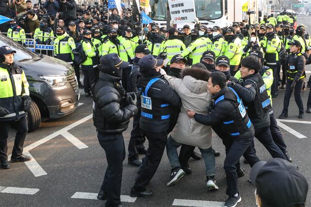 11일 오전 서울 서초구 대법원 정문 앞에서 양승태 전 대법원장의 구속을 촉구하며 1인 시위를 하던 한 시민이 대국민 입장문 발표를 마치고 검찰로 향하던 양승태 전 대법원장이 탑승한 차량을 향해 뛰어들다 경찰에게 저지당하고 있다.   전직 대법원장이 피의자 신분으로 검찰 조사를 받는 것은 헌정 사상 처음있는 일이다. 2019.1.11 뉴스1