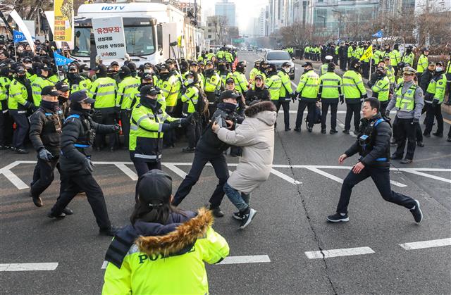 11일 오전 서울 서초구 대법원 정문 앞에서 양승태 전 대법원장의 구속을 촉구하며 1인 시위를 하던 한 시민이 대국민 입장문 발표를 마치고 검찰로 향하던 양승태 전 대법원장이 탑승한 차량을 향해 뛰어들다 경찰에게 저지당하고 있다.   전직 대법원장이 피의자 신분으로 검찰 조사를 받는 것은 헌정 사상 처음있는 일이다. 2019.1.11 뉴스1