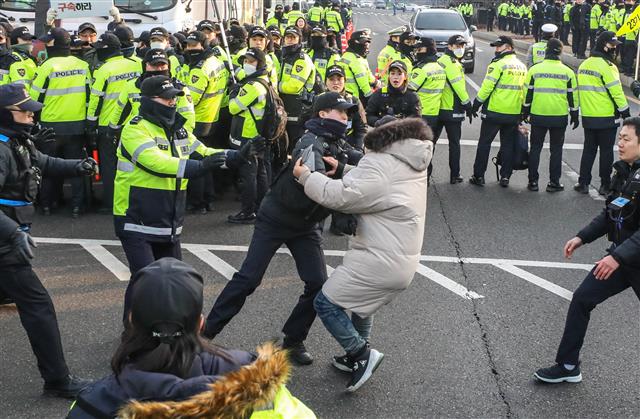 11일 오전 서울 서초구 대법원 정문 앞에서 양승태 전 대법원장의 구속을 촉구하며 1인 시위를 하던 한 시민이 대국민 입장문 발표를 마치고 검찰로 향하던 양승태 전 대법원장이 탑승한 차량을 향해 뛰어들다 경찰에게 저지당하고 있다.   전직 대법원장이 피의자 신분으로 검찰 조사를 받는 것은 헌정 사상 처음있는 일이다. 2019.1.11 뉴스1