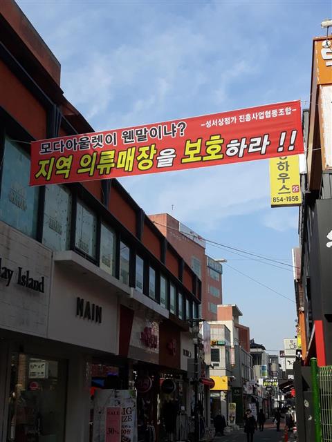 충주시내에 걸려 있는 모다아울렛 반대 현수막. <br>성서상점가 진흥사업협동조합 제공