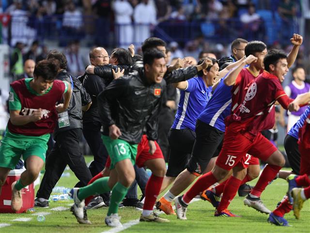 베트남이 승부차기 끝에 요르단을 물리치고 AFC 아시안컵 첫 8강에 오른 순간 코칭스태프와 끌어안고, 벤치에 있던 스태프와 선수들이 그라운드에 뛰어들어가고 있다. 두바이 뉴스1