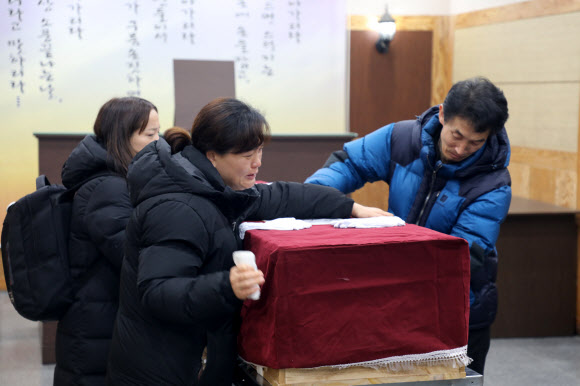 장례식장을 서울로 옮기려고 22일 오전 태안장례식장 상례원에서 고 김용균씨가 안치된 관을 이송하자 김씨의 부모가 관을 어루만지며 눈물을 흘리고 있다. 2019.1.22  연합뉴스