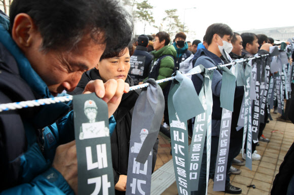 고 김용균 씨의 아버지와 어머니가 22일 세종시 정부세종청사 산업통상자원부 앞에서 열린 ‘고 김용균 노동자 사회적 타살?죽음의 외주화 주범 산업통상자원부 규탄’ 기자회견에서 ‘내가 김용균이다’ 검은 리본을 묶으며 눈물을 흘리고 있다.  2019.1.22  연합뉴스