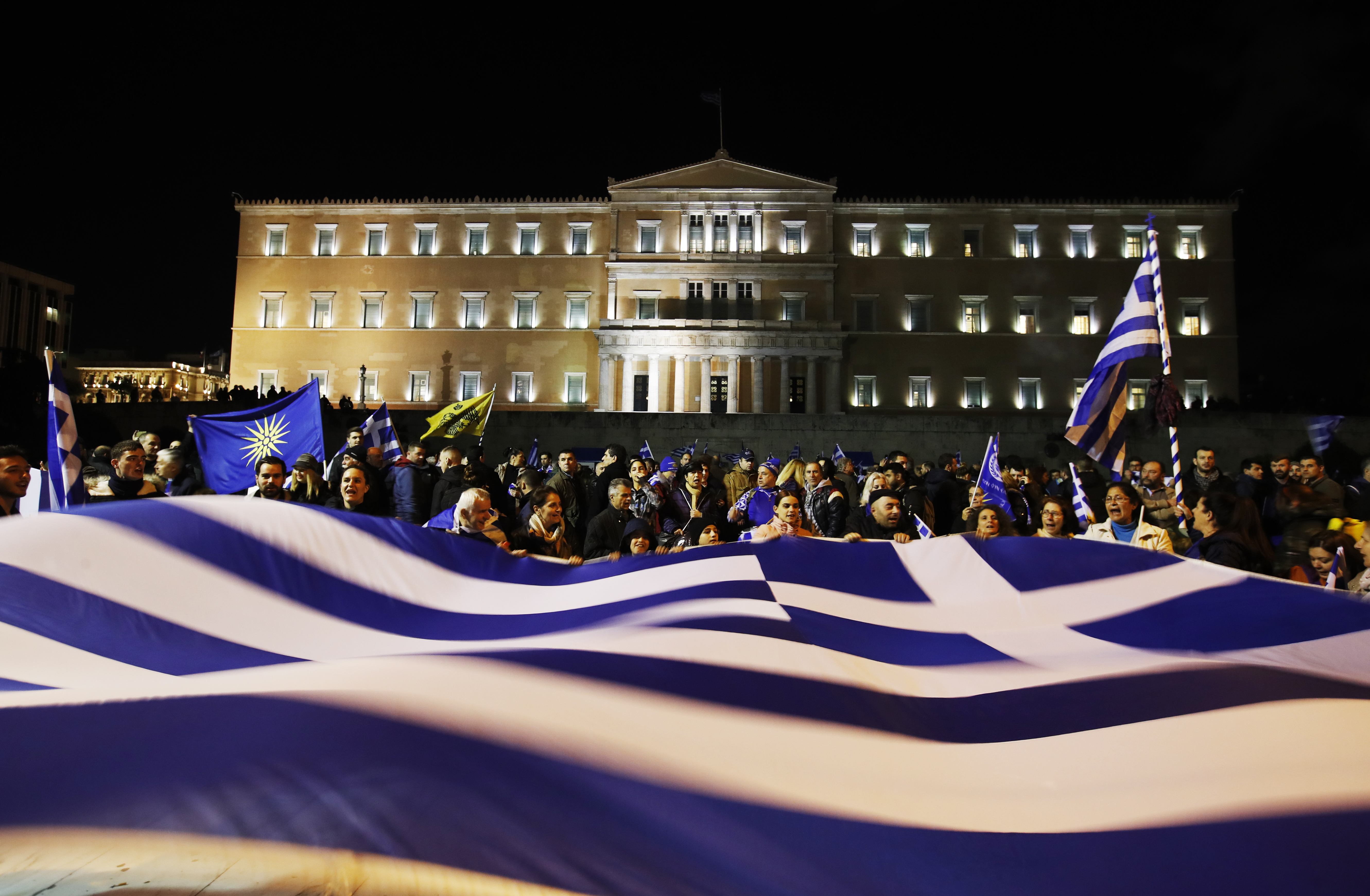 그리스 의회에서 이웃나라 마케도니아와의 국호 변경 합의안에 대한 표결이 예정된 24일(현지시간) 아테네 의회 의사당 앞에서 합의안에 반대하는 그리스인들이 대형 그리스 국기를 펼쳐든 채 시위를 벌이고 있다. AP 연합뉴스