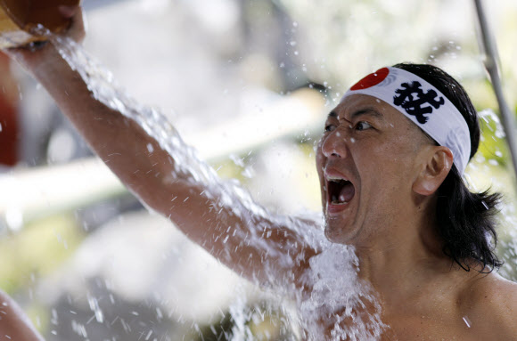 참가자들이 26일(현지시간) 일본 도쿄의 칸다 묘진에서 열린 ‘다이코쿠 축제’ 중 정화 행사를 위해 차가운 물을 쏟아붓고 있다. 마음을 갈고 닦고 정신을 깨끗하게 해준다고 여겨왔던 연례 신년 차가운 목욕 의식에 약 40명이 참가했다. EPA 연합뉴스