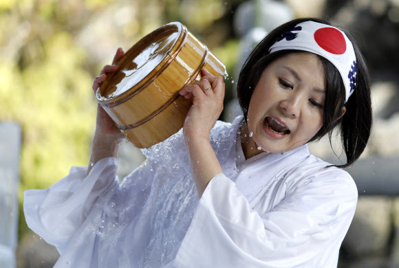 참가자들이 26일(현지시간) 일본 도쿄의 칸다 묘진에서 열린 ‘다이코쿠 축제’ 중 정화 행사를 위해 차가운 물을 쏟아붓고 있다. 마음을 갈고 닦고 정신을 깨끗하게 해준다고 여겨왔던 연례 신년 차가운 목욕 의식에 약 40명이 참가했다. EPA 연합뉴스