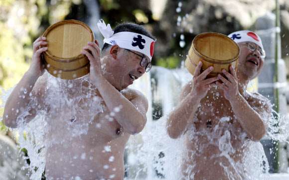 참가자들이 26일(현지시간) 일본 도쿄의 칸다 묘진에서 열린 ‘다이코쿠 축제’ 중 정화 행사를 위해 차가운 물을 쏟아붓고 있다. 마음을 갈고 닦고 정신을 깨끗하게 해준다고 여겨왔던 연례 신년 차가운 목욕 의식에 약 40명이 참가했다. EPA 연합뉴스