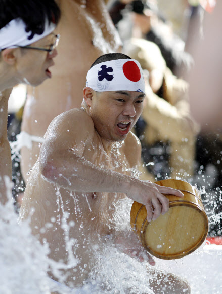 참가자들이 26일(현지시간) 일본 도쿄의 칸다 묘진에서 열린 ‘다이코쿠 축제’ 중 정화 행사를 위해 차가운 물을 쏟아붓고 있다. 마음을 갈고 닦고 정신을 깨끗하게 해준다고 여겨왔던 연례 신년 차가운 목욕 의식에 약 40명이 참가했다. EPA 연합뉴스