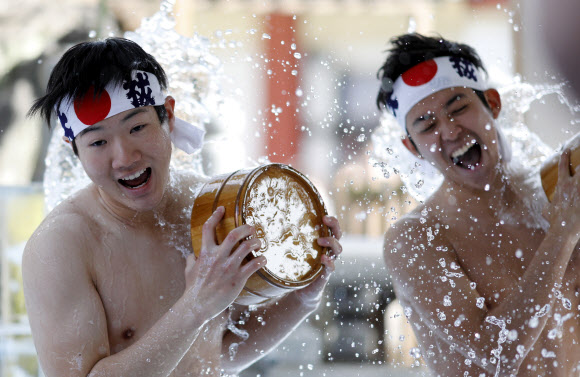 참가자들이 26일(현지시간) 일본 도쿄의 칸다 묘진에서 열린 ‘다이코쿠 축제’ 중 정화 행사를 위해 차가운 물을 쏟아붓고 있다. 마음을 갈고 닦고 정신을 깨끗하게 해준다고 여겨왔던 연례 신년 차가운 목욕 의식에 약 40명이 참가했다. EPA 연합뉴스