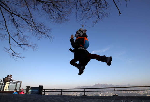 미세먼지 농도가 ‘좋음’ 수준을 보인 27일 오전 서울 중구 남산을 찾은 외국인 관광객들이 점프하며 기념촬영하고 있다. 2019.1.27  연합뉴스