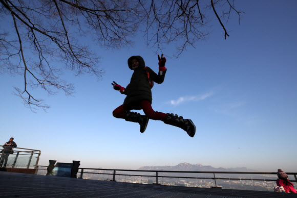 미세먼지 농도가 ‘좋음’ 수준을 보인 27일 오전 서울 중구 남산을 찾은 외국인 관광객들이 점프하며 기념촬영하고 있다. 2019.1.27  연합뉴스