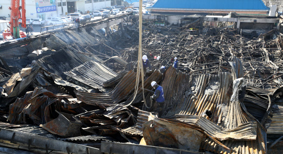 27일 오전 울산시 남구 농수산물도매시장 수산물 소매동 화재 현장에서 불에 타 무너진 지붕을 철거해 한쪽으로 모아두는 작업이 이뤄지고 있다. 2019.1.27  연합뉴스