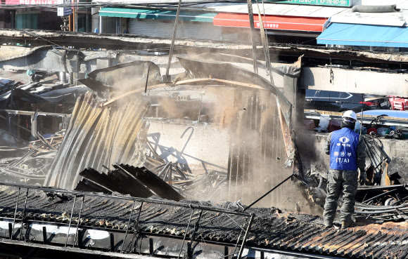 27일 오전 울산시 남구 농수산물도매시장 수산물 소매동 화재 현장에서 불에 타 무너진 지붕을 철거해 한쪽으로 모아두는 작업이 이뤄지고 있다. 2019.1.27  연합뉴스