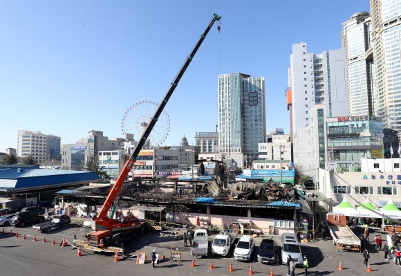 27일 오전 울산시 남구 농수산물도매시장 수산물 소매동 화재 현장에서 대형 크레인으로 불에 타 무너진 지붕을 철거해 한쪽으로 모아두는 작업이 이뤄지고 있다. 2019.1.27  연합뉴스