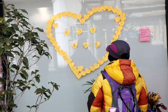 27일 오후 전남 목포시 근대역사문화공간을 찾은 한 관광객이 손혜원 의원의 조카가 운영하는 카페에 붙어있는 응원글을 읽고 있다. 2019.1.27  연합뉴스