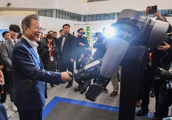 문재인 대통령이 29일 오전 서울 동대문디자인플라자에서 개막한 한국 전자?IT산업 융합 전시회를 방문해 네이버랩스의 지능형 로봇팔과 악수하고 있다. 이 로봇팔을 이용하면 100kg이 넘는 물건을 손으로 밀며 이동시킬 수 있다. 2019. 1. 29 도준석 기자 pado@seoul.co.kr