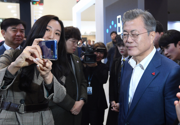 문재인 대통령이 29일 오전 서울 동대문디자인플라자에서 개막한 한국 전자?IT산업 융합 전시회를 방문해 삼성 C 랩인 모픽이 개발한 스냅 3D 휴대전화 케이스를 살펴보며 한쪽 눈을 감아보고 있다. 이 케이스를 이용하면 3D 안경 없이 입체화면을 볼 수 있다. 2019. 1. 29 도준석 기자 pado@seoul.co.kr