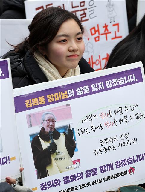 30일 서울 종로구 옛 일본대사관 앞에서 열린 일본군성노예제 문제해결을 위한 정기수요시위에서 참가자들이 김복동 할머니 사진이 담긴 팻말을 들고 있다.  김복동 할머니의 별세로 위안부피해자는 23명만 남았다. 2019.1.30 뉴스1