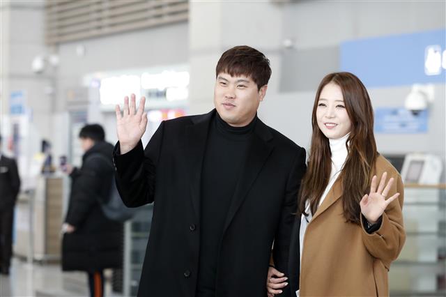 류현진(왼쪽)이 30일 인천국제공항을 통해 미국으로 출국하기에 앞서 부인 배지현씨와 함께 손을 흔들고 있다.  뉴스1