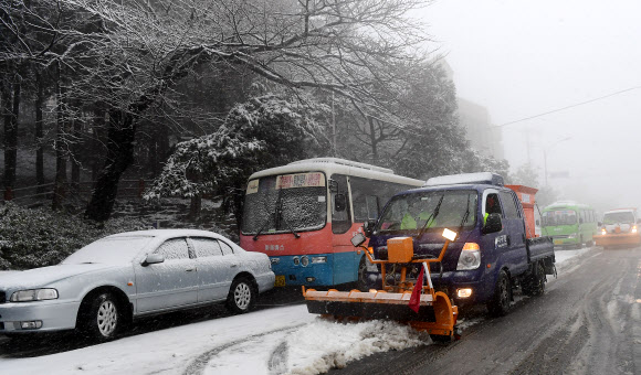멈춰선 마을버스 옆 제설작업