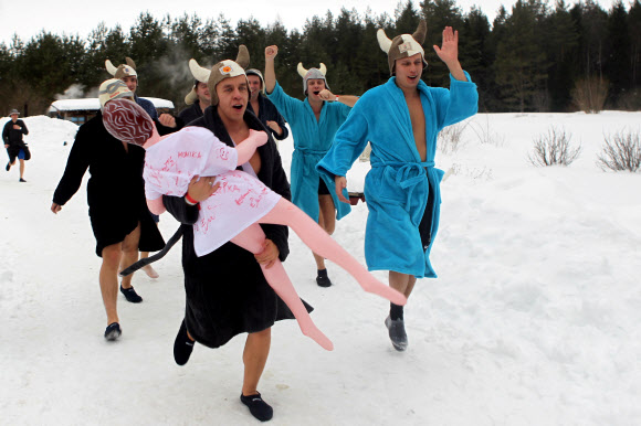 참가자들이 2일(현지시간) 에스토니아 오테파에서 열린 ‘사우나 마라톤’ 중 가운을 입고 달리고 있다. 참가자들은 오테파 지역의 지정된 사우나를 찾은 후 최대한 빨리 방문해야한다. 최단시간에 모든 사우나를 완료한 팀이 이기게 된다. EPA 연합뉴스